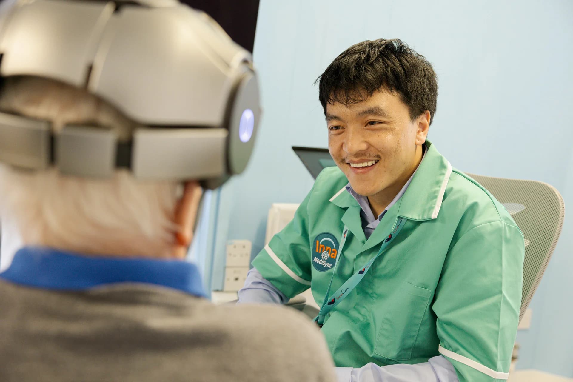 Kalsang Luna smiling with a patient during a neurotherapy session at Inna MediSync